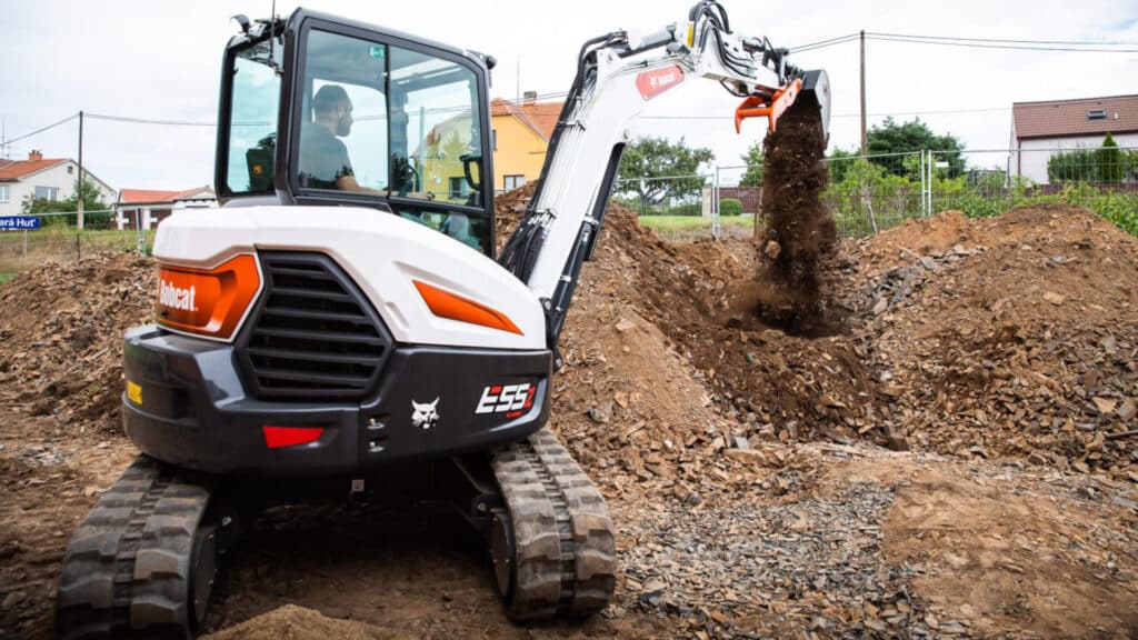 The Bobcat E55z Mini Excavator efficiently handles debris and soil with its advanced grapple attachment, demonstrating its precision and reliability in site preparation and material handling tasks.