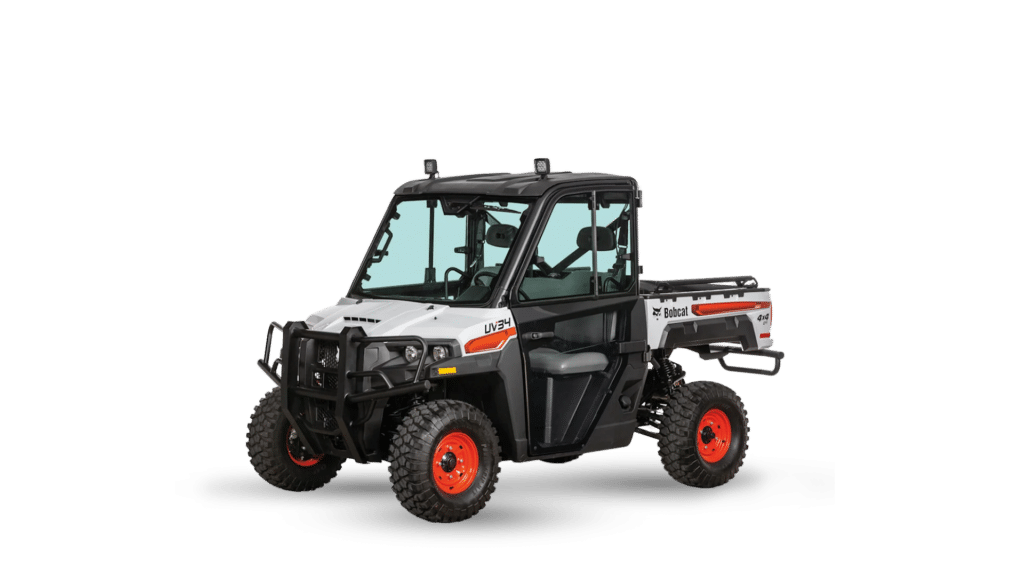 A Bobcat UV34 Side by Side Utility Vehicle, featuring a rugged and durable design in white and black with orange accents. This 4x4 utility vehicle is equipped with a fully enclosed cab, heavy-duty tyres, and a spacious cargo bed, making it ideal for tough jobs in construction, farming, and off-road environments.