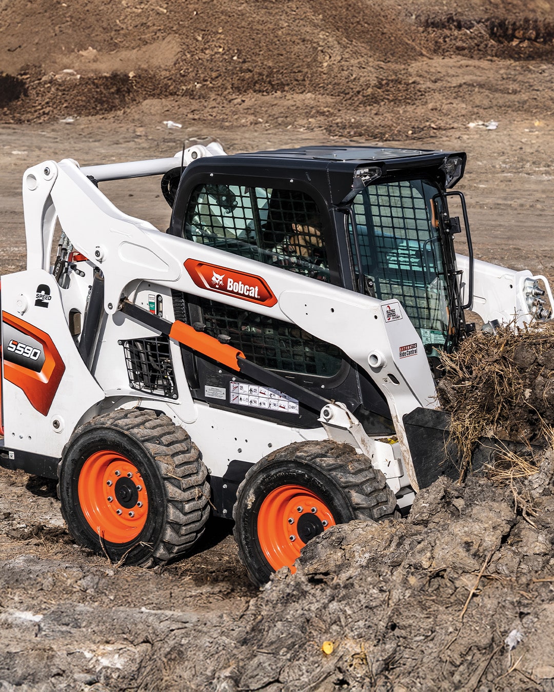 Bobcat S590 Skid Steer Loader working on a construction site, moving soil and debris with precision and power.