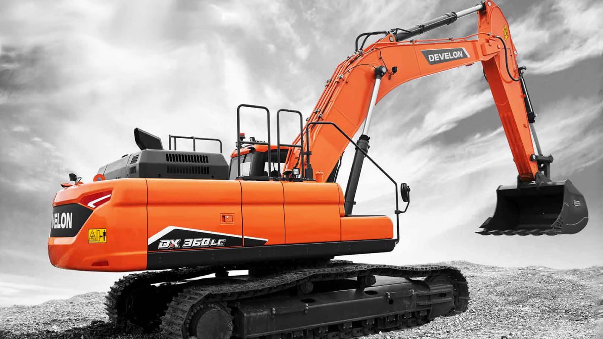 The bright orange Develon DX360LC-7M Large Excavator positioned on a rugged gravel site with a dramatic cloudy sky in the background. The excavator features durable rubber tracks, a spacious enclosed cabin with excellent visibility, and a powerful hydraulic arm equipped with a heavy-duty digging bucket. The bold orange color of the machine contrasts strikingly against the grayscale environment, emphasizing its robust build and commanding presence on the worksite. Ideal for heavy-duty excavation and earthmoving tasks.