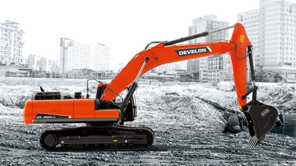 The bright orange Develon DX360LC-7M Large Excavator positioned on a rugged construction site with an urban skyline in the background. The excavator features durable rubber tracks, a spacious enclosed cabin with large windows, and a powerful hydraulic arm equipped with a heavy-duty claw bucket. The vivid orange color of the machine contrasts sharply against the monochrome cityscape, emphasizing its modern design and robust presence. Ideal for demanding earthmoving and excavation tasks in urban and industrial environments.