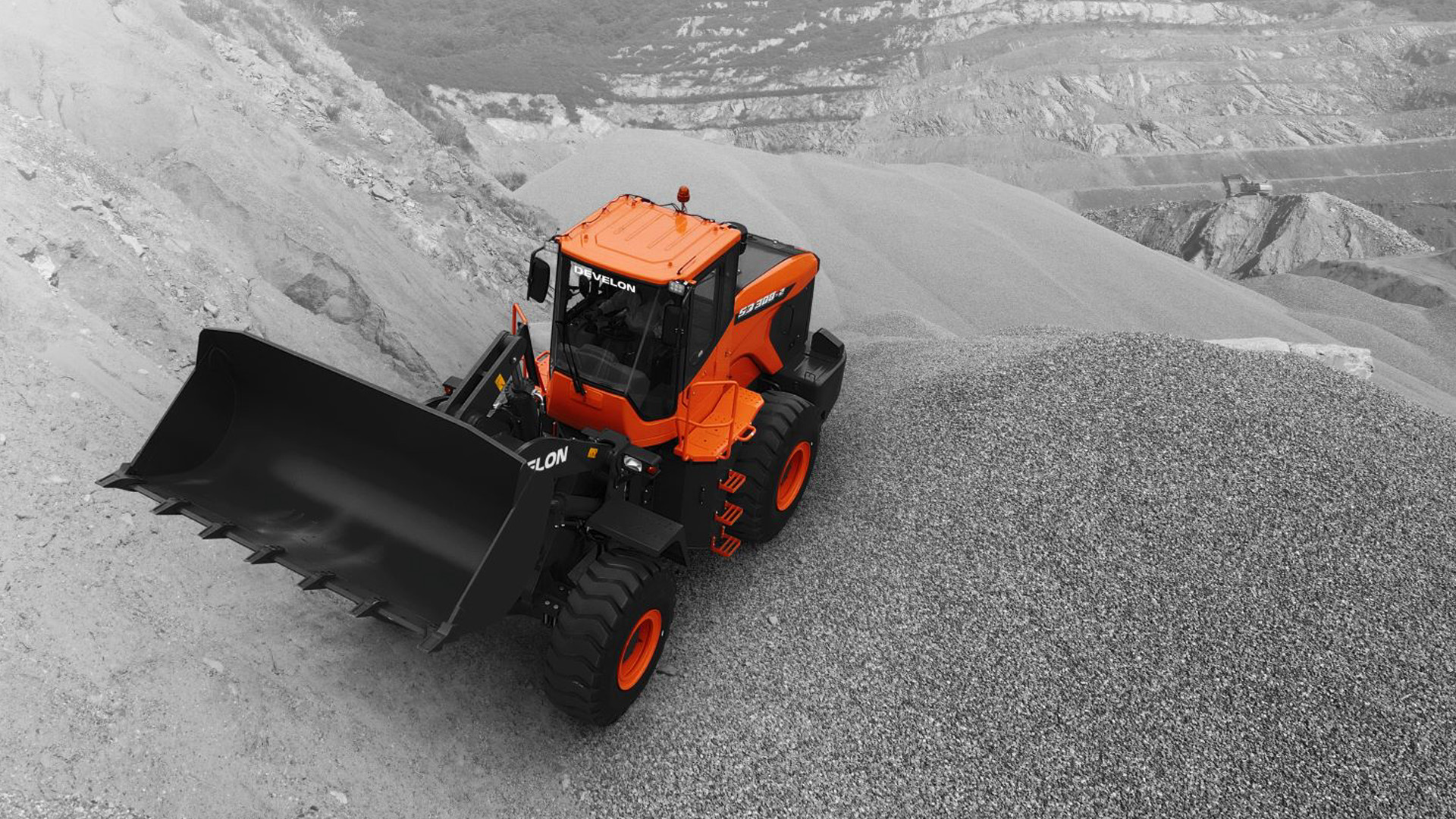 A Develon SD300 Wheel Loader positioned on a steep gravel slope in a quarry, equipped with a rugged front bucket, built for reliable performance in demanding material handling environments.