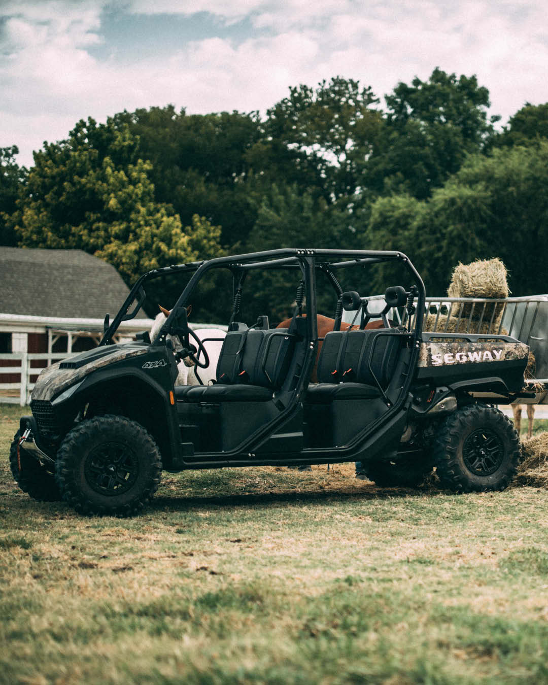 A Delecca's Dry Hire Segway UTV loaded with hay bales on a rural property, highlighting its six-seat capacity and rugged performance for farm and acreage use.