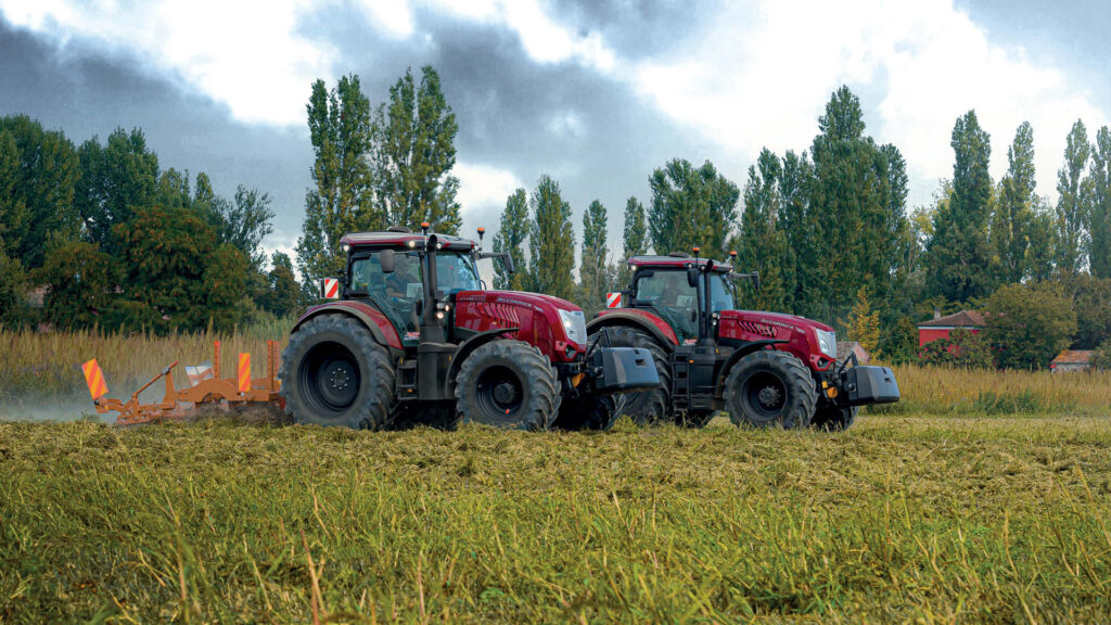 Two McCormick X Series tractors working side by side in a lush green paddock, showcasing their high-powered performance and durability in tough farming conditions.