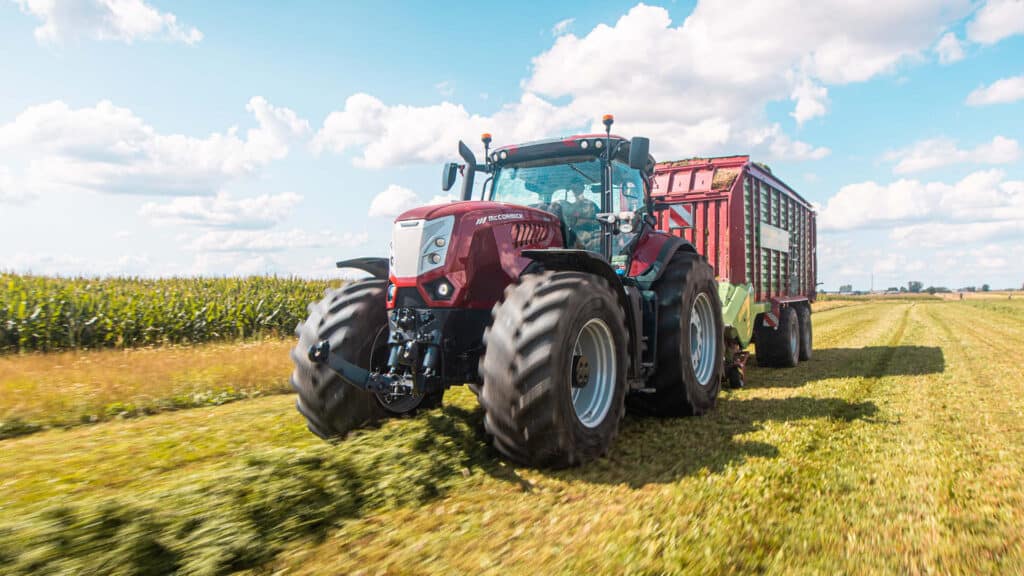 McCormick X8 Series tractor hauling a heavy silage trailer through a freshly cut paddock — unmatched power and productivity now with 0.99% finance from Delecca’s.
