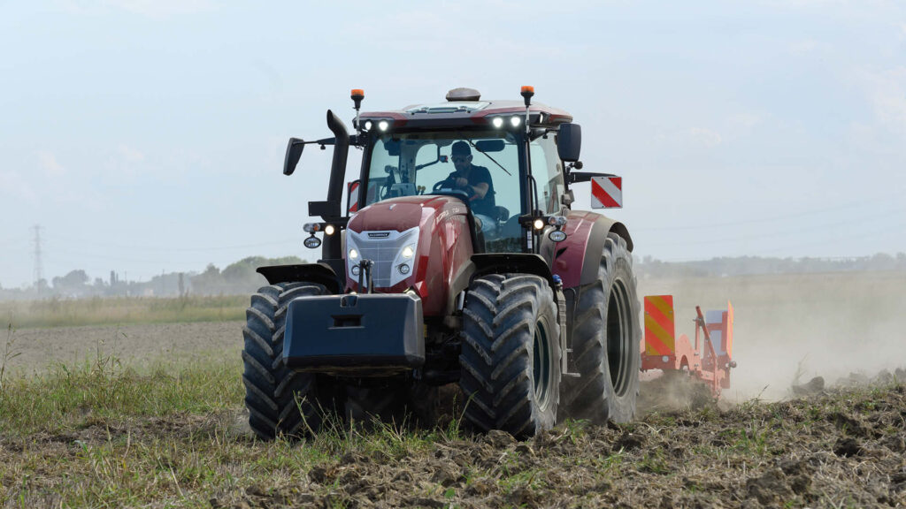 A McCormick X7 tractor working through a dusty paddock with a plough attached, highlighting tractors for sale in Victoria.