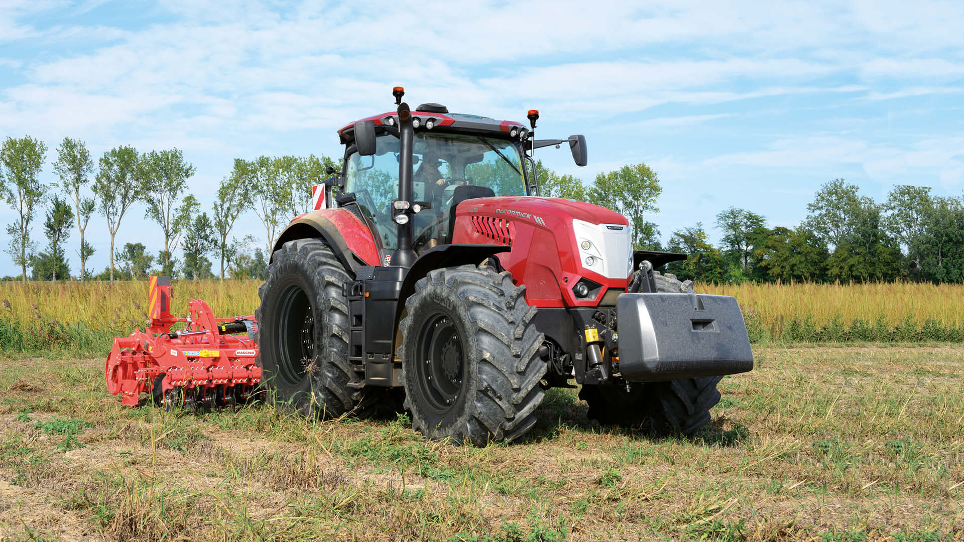 A red McCormick X8 farm tractor parked in a dry paddock with a disc harrow attached, promoting farm tractor for sale in Victoria.