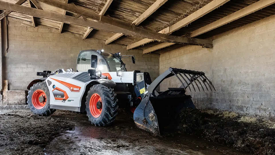 Bobcat TL30.60 telehandler for sale cleaning out a farm shed, showing compact power and reach for agricultural work.