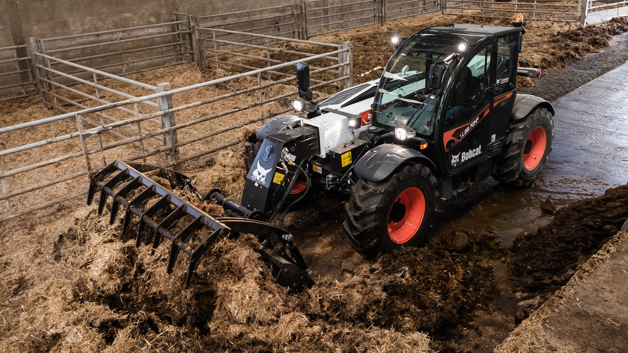 Bobcat TL38.70HF telehandler for sale cleaning out livestock pens, showing strength and manoeuvrability for farm chores.