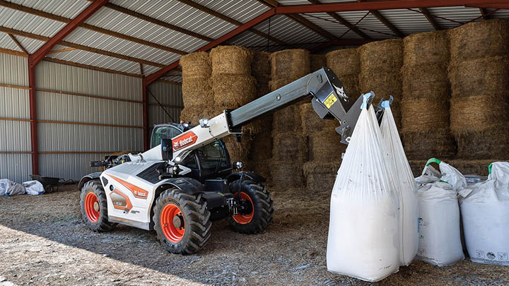 Bobcat TL30.60 agricultural telehandler lifting bulk bags in farm hay shed