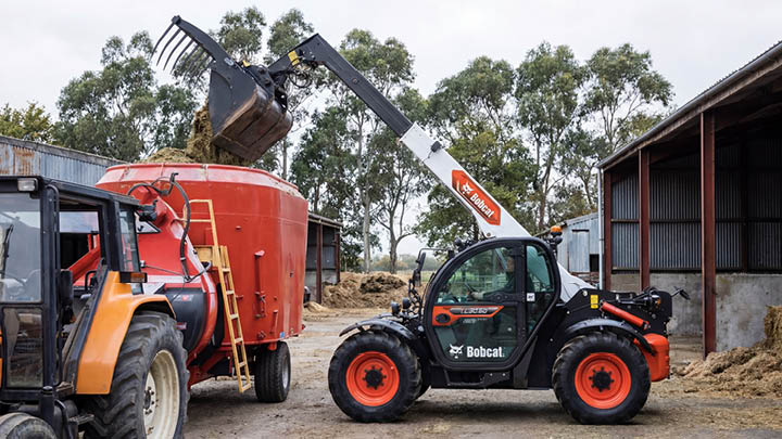 Bobcat TL30.60 agricultural telehandler loading silage into feed mixer wagon on Australian dairy farm