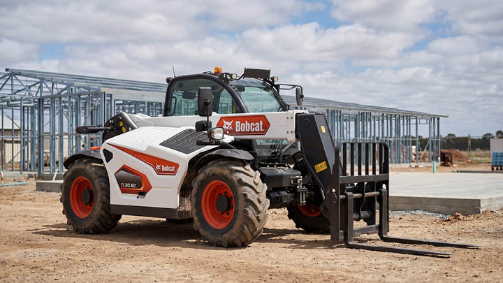 Bobcat TL30.60 construction telehandler with pallet forks, stationary on a central Victoria construction site with steel frame structure in background