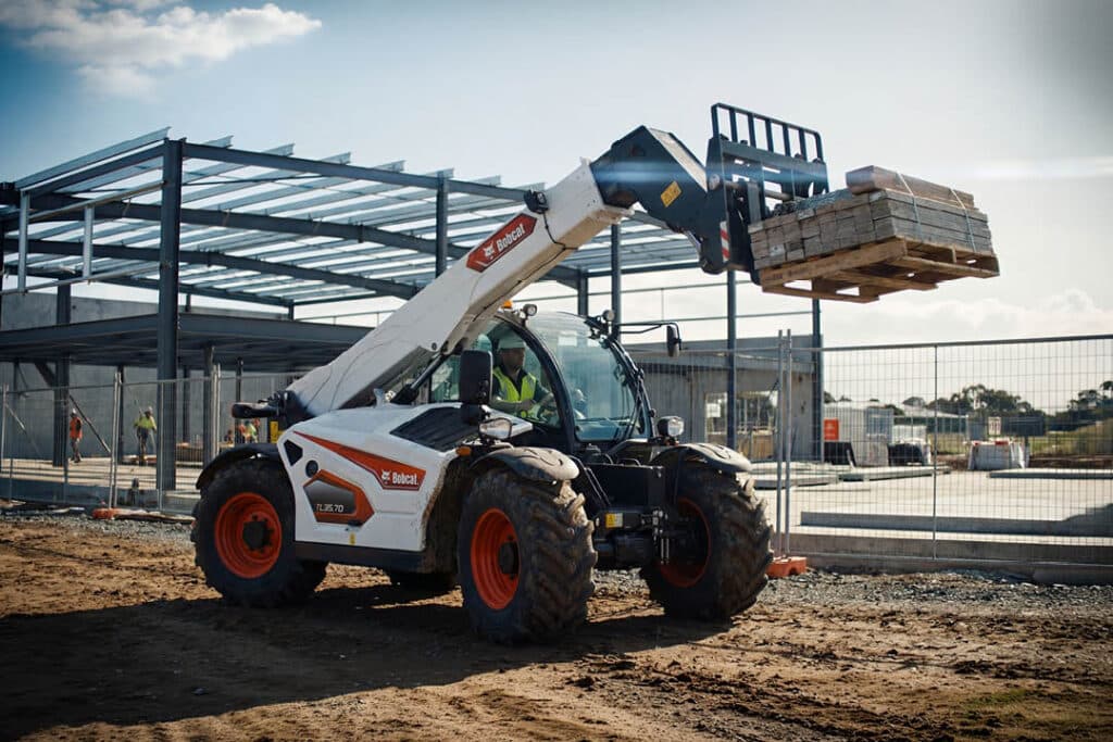 Bobcat TL35.70 construction telehandler lifting a pallet of timber on a commercial construction site in central Victoria