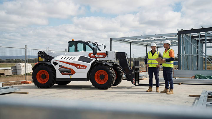 Bobcat TL35.70 construction telehandler with two site professionals reviewing specifications on a commercial construction site in Victoria
