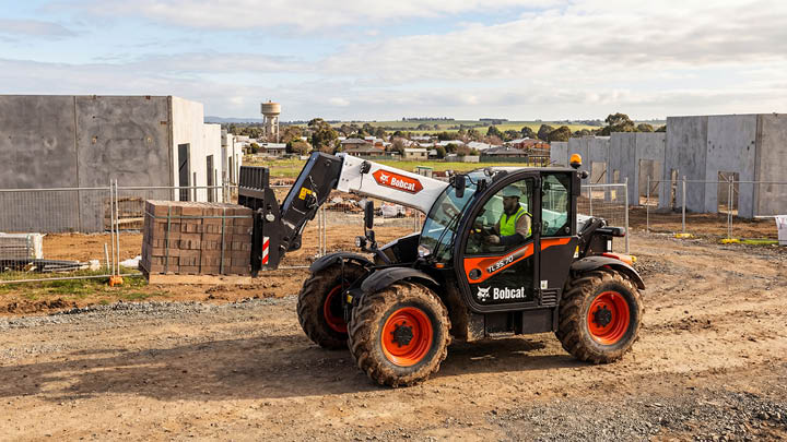 Bobcat TL35.70 construction telehandler handling materials on a light commercial construction site on the edge of a regional Victorian town, operator in cab