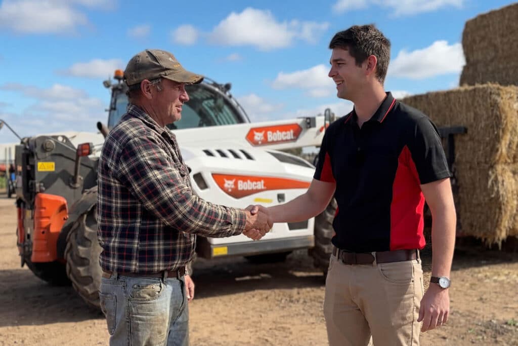 Delecca's sales team member with farmer and Bobcat telehandler on Central Victoria farm